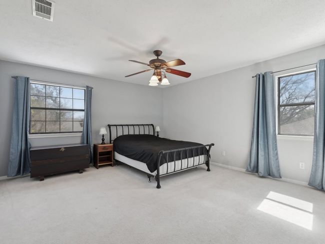 Bedroom with visible vents, ceiling fan, baseboards, and carpet | Image 22
