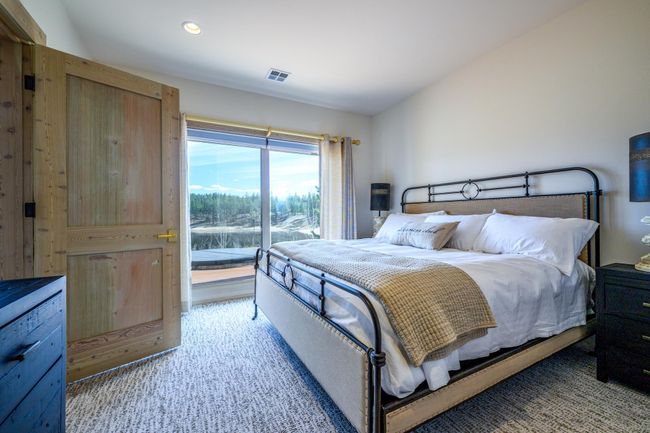 Lower level en-suite with floor-to-ceiling glass windows and doors, offering direct access to the patio | Image 24