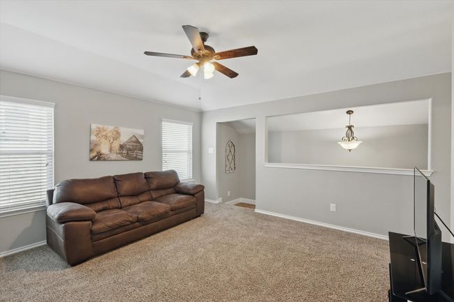 Living room featuring ceiling fan, carpet, and baseboards | Image 23