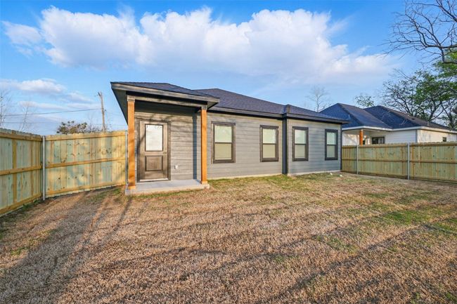 Rear view of property with a fenced backyard and a lawn | Image 5