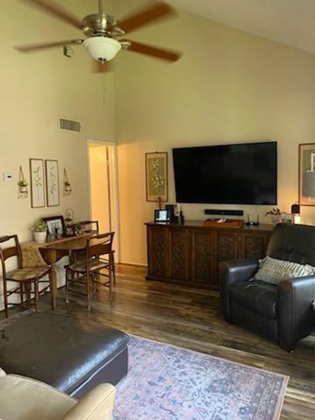 Soaring lofted ceilings with ceiling fan in family room. | Image 6