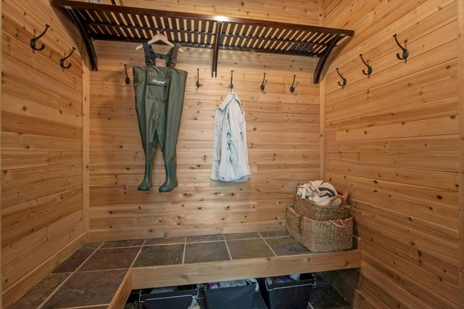 Mudroom with a sauna / steam room, wooden walls, and stone finish flooring | Image 33