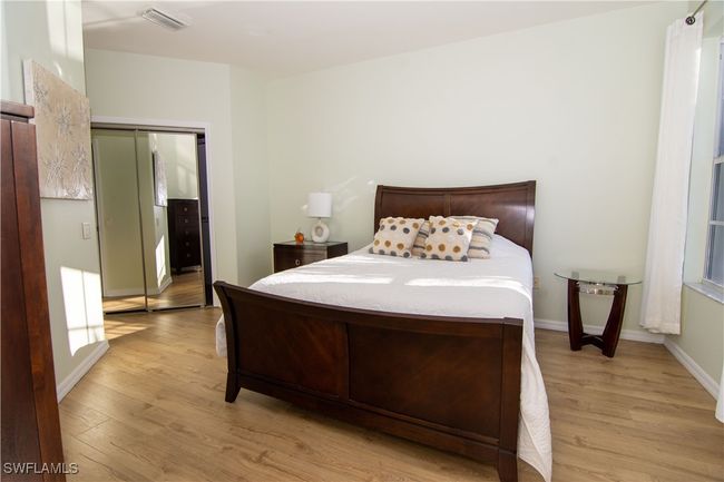 Primary bedroom has 2 walk in closets, a pretty chandelier and gorgeous flooring. | Image 15