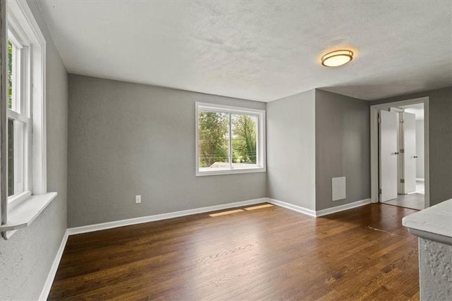 Spare room with dark wood-style floors, a textured wall, and a textured ceiling | Image 17