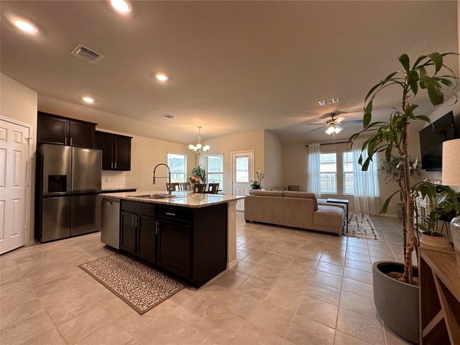 Kitchen with appliances with stainless steel finishes, a sink, a chandelier, ceiling fan, and open floor plan | Image 19