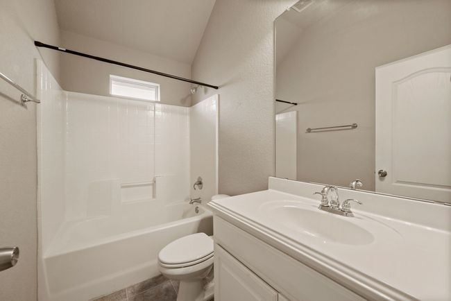 Bathroom with shower / bath combination, vaulted ceiling, vanity, and toilet | Image 25