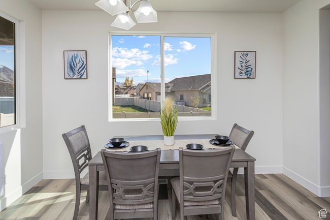 Dining space featuring an inviting chandelier, wood finished floors, and baseboards | Image 14