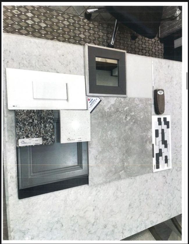 This photo showcases a variety of interior design samples, including countertop materials, cabinet finishes, and tile options, arranged on a light-colored surface, ideal for visualizing potential home design choices. | Image 33