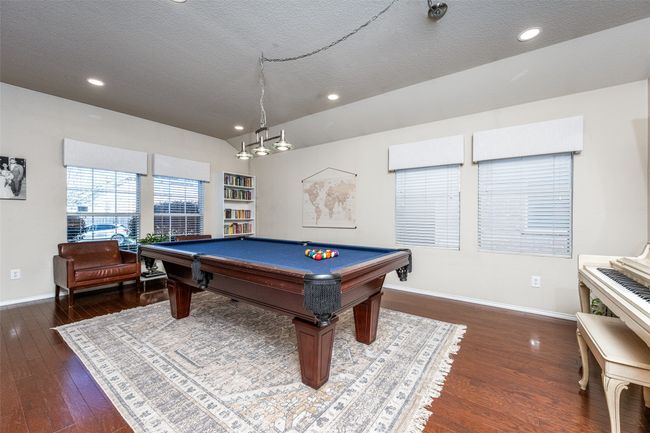 Recreation room with a textured ceiling, wood finished floors, recessed lighting, and pool table | Image 6