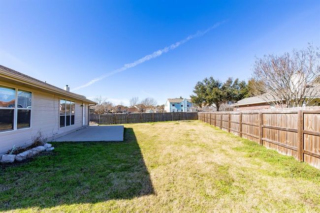 Fenced backyard with a patio | Image 29