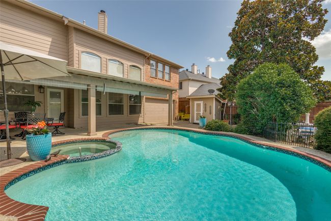 View of backyard, pool, rear entry garage, storage shed, and additional secured driveway parking due to wood electric gate. | Image 5