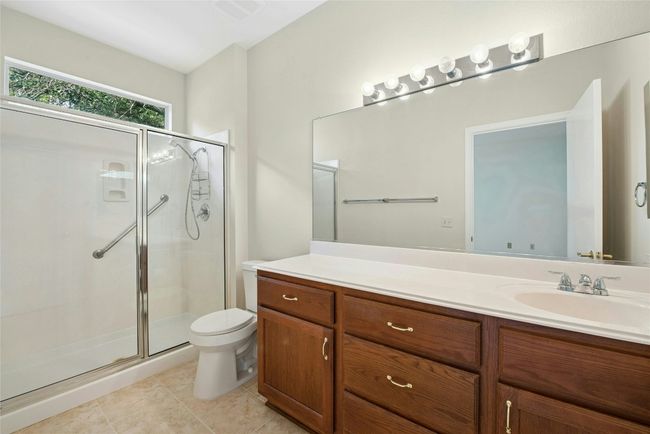 Bathroom with a shower stall, vanity, toilet, and tile patterned floors | Image 18