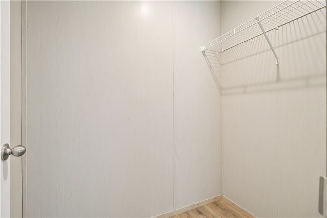 Walk in closet with light wood-style flooring | Image 17