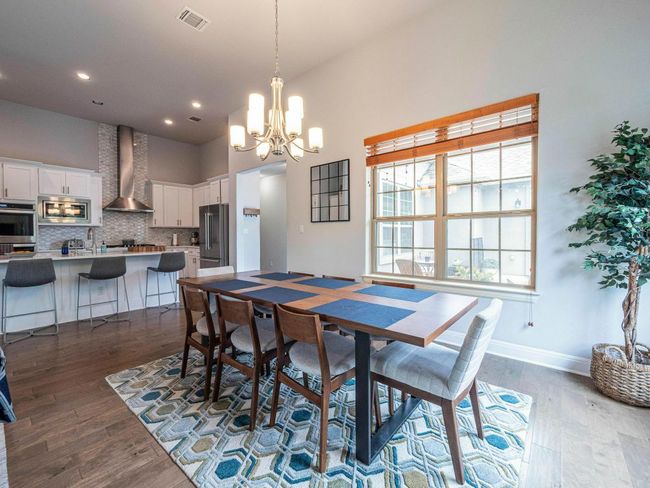 Dining area featuring a chandelier, dark wood finished floors, a towering ceiling, and recessed lighting | Image 8