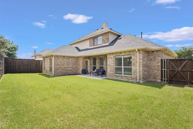 Rear view of house featuring brick siding, a patio area, roof with shingles, and a gate | Image 29