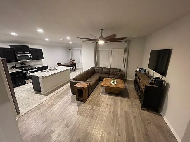 Living room with a ceiling fan, baseboards, recessed lighting, and light wood-style floors | Image 4