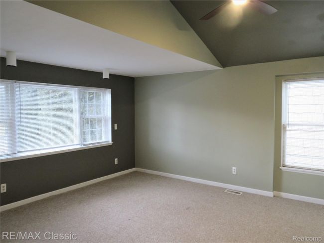 Master bedroom has tall ceilings and paddle fan. | Image 15