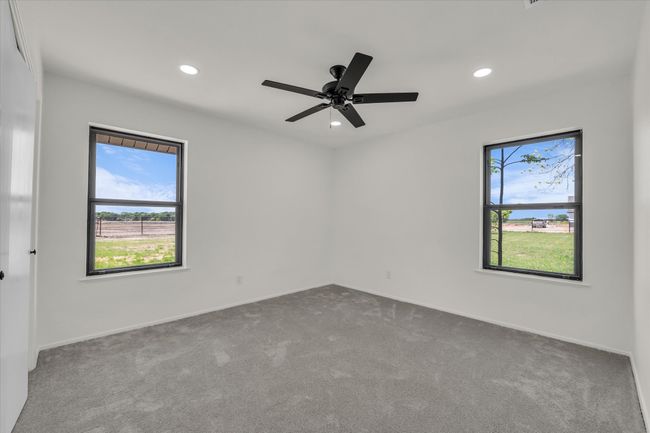 Empty room featuring dark colored carpet, a ceiling fan, baseboards, and recessed lighting | Image 29