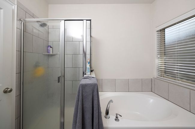 Bathroom featuring a garden tub and a shower stall | Image 32