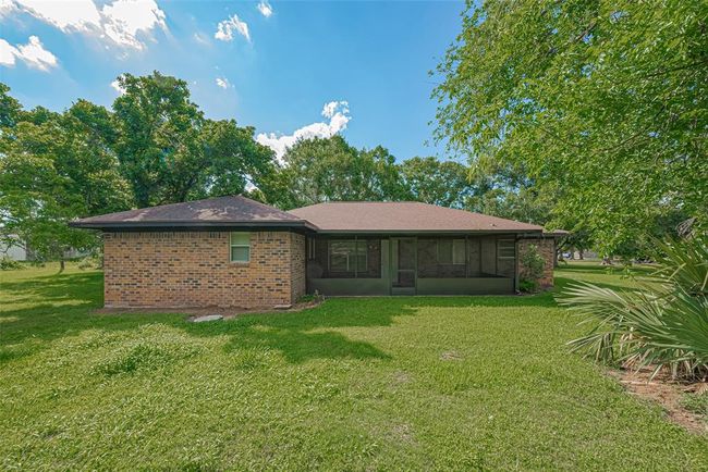Charming brick home with a spacious, well-maintained lawn and mature trees, providing ample shade and privacy. Ideal for outdoor relaxation and family gatherings. | Image 31