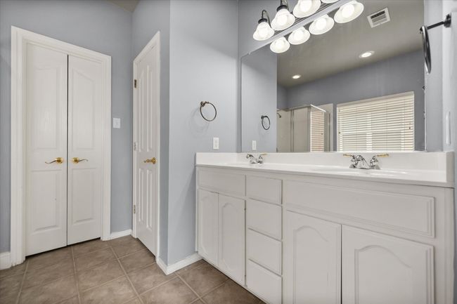 Bathroom featuring a stall shower, double vanity, and tile patterned flooring | Image 15