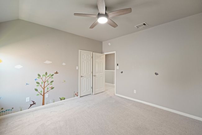 Unfurnished bedroom featuring carpet, baseboards, vaulted ceiling, and a ceiling fan | Image 23