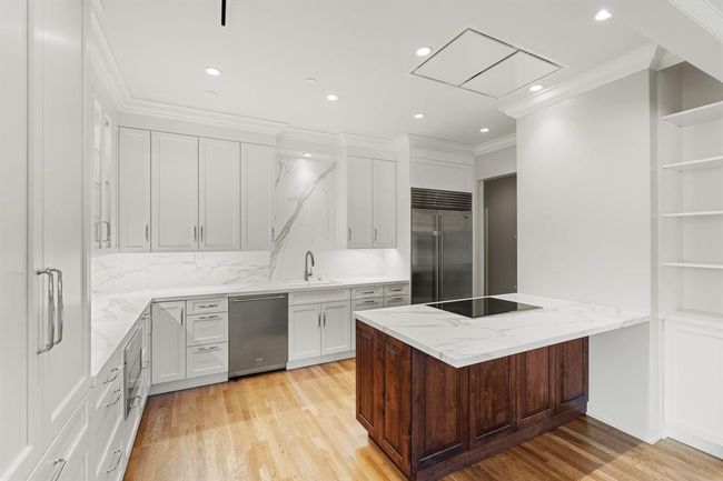 Breakfast bar seating and built-in shelving for display and cookbooks. | Image 11