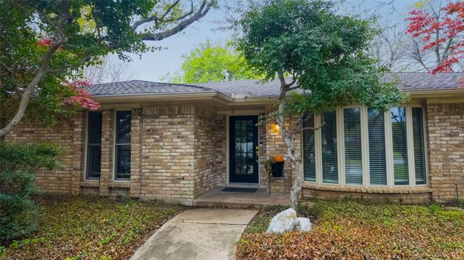 View of exterior entry with a shingled roof and brick siding | Image 4