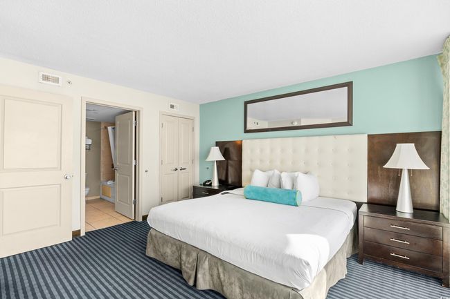Bedroom with tile patterned flooring, a closet, connected bathroom, and visible vents | Image 22