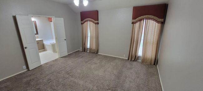 Unfurnished bedroom featuring carpet floors and vaulted ceiling | Image 9