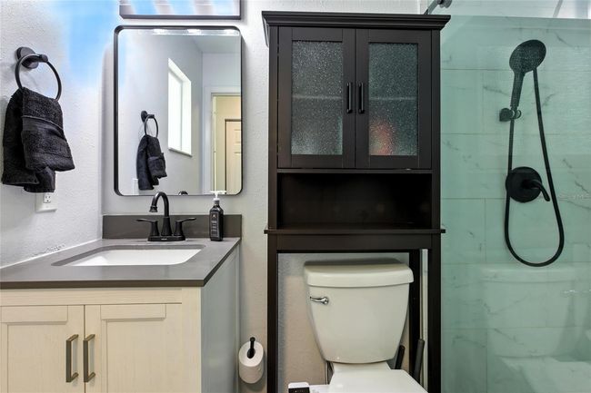 The primary ensuite features quartz countertops, upgraded shower hardware, and a new barn-style glass door—offering a sleek, modern finish with lasting durability | Image 33