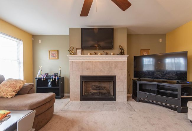 Living room featuring carpet floors, ceiling fan, and a tile fireplace | Image 15
