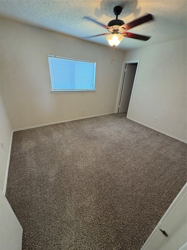 Spare room with a textured ceiling, carpet floors, and a ceiling fan | Image 15