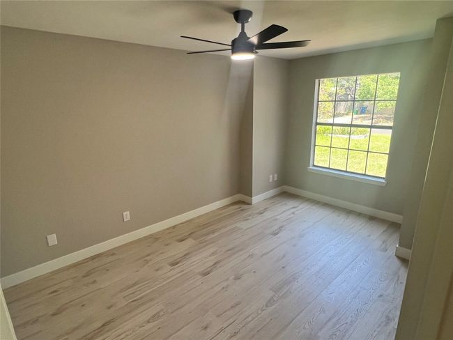 Spare room featuring light wood finished floors and a ceiling fan | Image 11