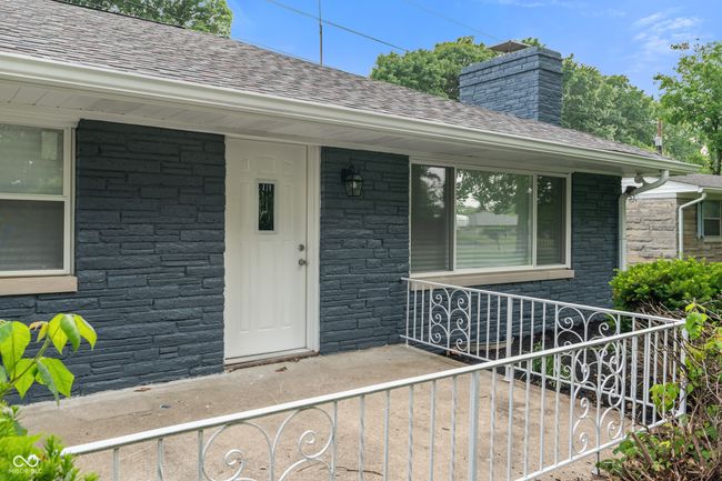 property entrance with stone siding and a shingled roof | Image 4