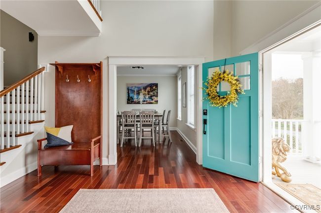 Entryway featuring crown molding, baseboards, stairs, wood finished floors, and a high ceiling | Image 5