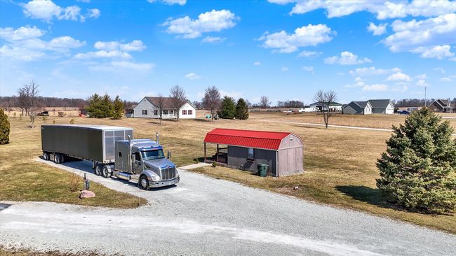 Finished Shed with little patio. SHE shed? HE shed? Office? You decide! There is power. No water, no heat source (Owner had a freestanding electric fireplace that was used to heat it the building. Sits just off the driveway. | Image 59
