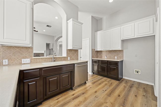 Kitchen featuring a sink, visible vents, light countertops, dishwasher, and dark brown cabinets | Image 13