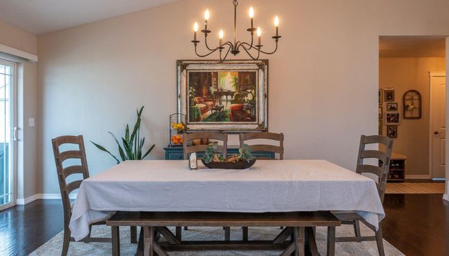 Dining room with dark wood-style floors, baseboards, and a chandelier | Image 14