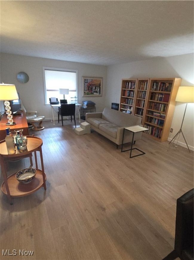 Living room with a textured ceiling, baseboards, and wood finished floors | Image 12
