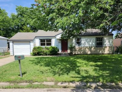 Ranch-style home featuring a front lawn and a garage | Image 1