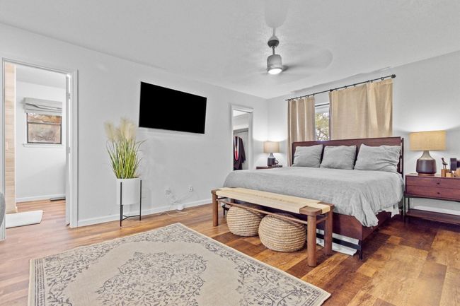 Bedroom with ceiling fan, hardwood / wood-style flooring, connected bathroom, a walk in closet, and a closet | Image 23