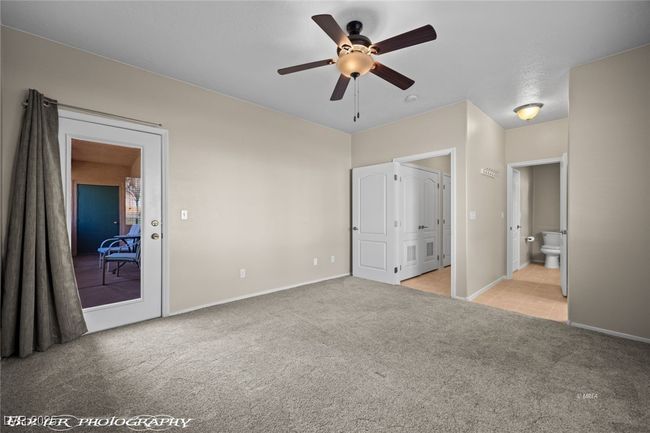 Unfurnished bedroom with light carpet, connected bathroom, baseboards, and ceiling fan | Image 22