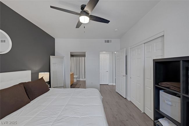 Bedroom with visible vents, a closet, wood finished floors, ensuite bathroom, and a ceiling fan | Image 19