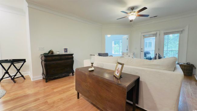 Living area with light wood-style flooring, a ceiling fan, and ornamental molding | Image 21