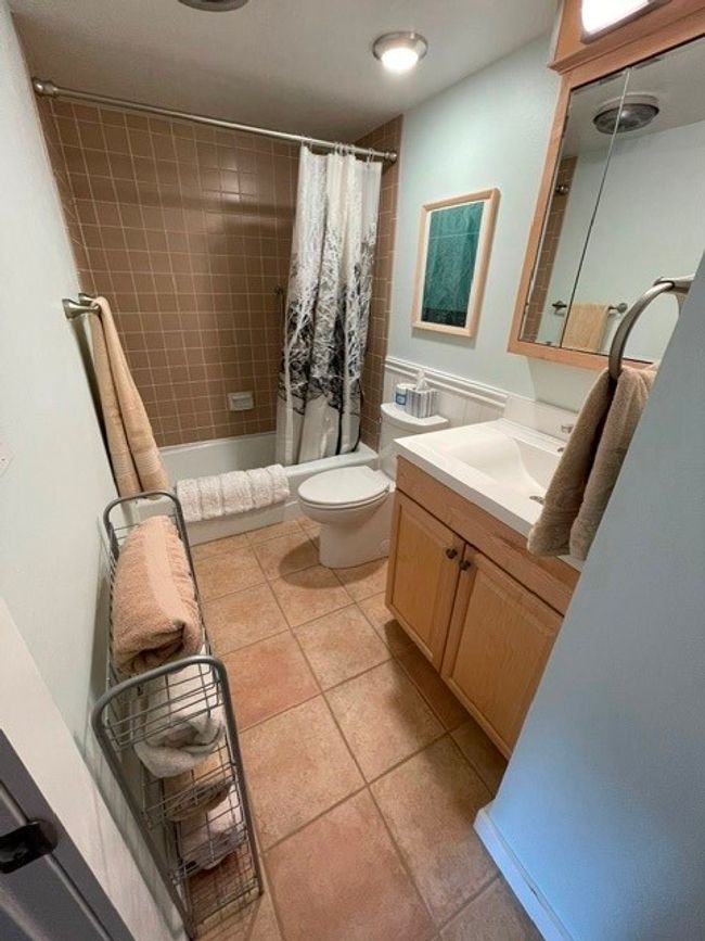 Full bathroom featuring tile patterned floors, shower / bathtub combination with curtain, toilet, and vanity | Image 12