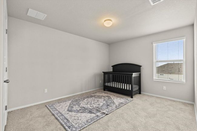 Unfurnished bedroom with carpet floors, baseboards, and a crib | Image 28