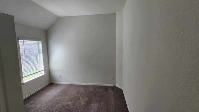 Unfurnished room featuring carpet floors, plenty of natural light, baseboards, and lofted ceiling | Image 16