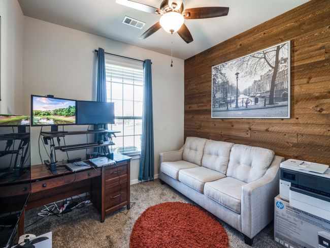 Carpeted office featuring wood walls, visible vents, an accent wall, and ceiling fan | Image 27