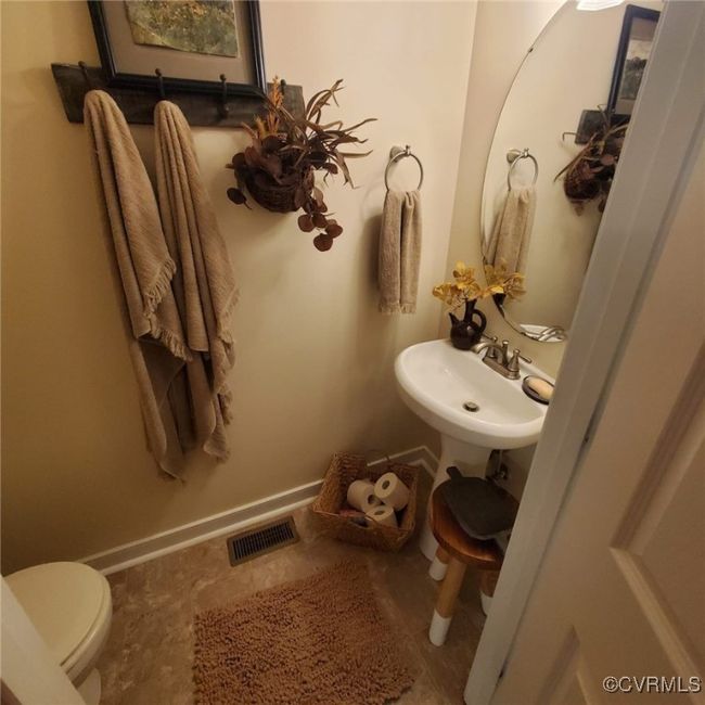 Bathroom featuring toilet, baseboards, visible vents, and a sink | Image 30